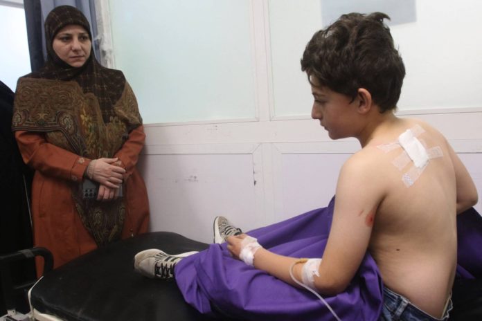 الطفل قاسم جفال يتلقى العلاج في مستشفى النبطية بعد إصابة حافلة تُقله إلى المدرسة بضربة إسرائيلية (أ.ف.ب)