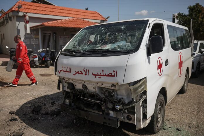 A staff member walks past a damaged Lebanese Red Cross vehicle after a drone strike damaged vehicles and a building, slightly injuring three workers, in Tyre, Lebanon, April 13, 2026. REUTERS/Louisa Gouliamaki